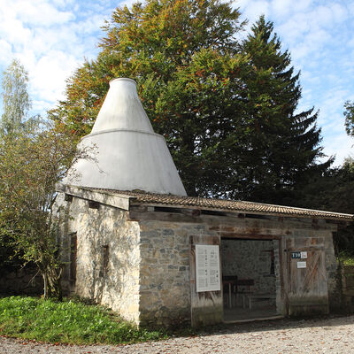 This lime kiln is a facsimile of a kiln which still stands in Lenggries. A stone vestibule with a pitch roof is linked with the combustion chamber and chimney. The lime burned here was used to produce mortar, to paint walls and as a fertiliser. Burning lime was a profitable sideline for farmers.