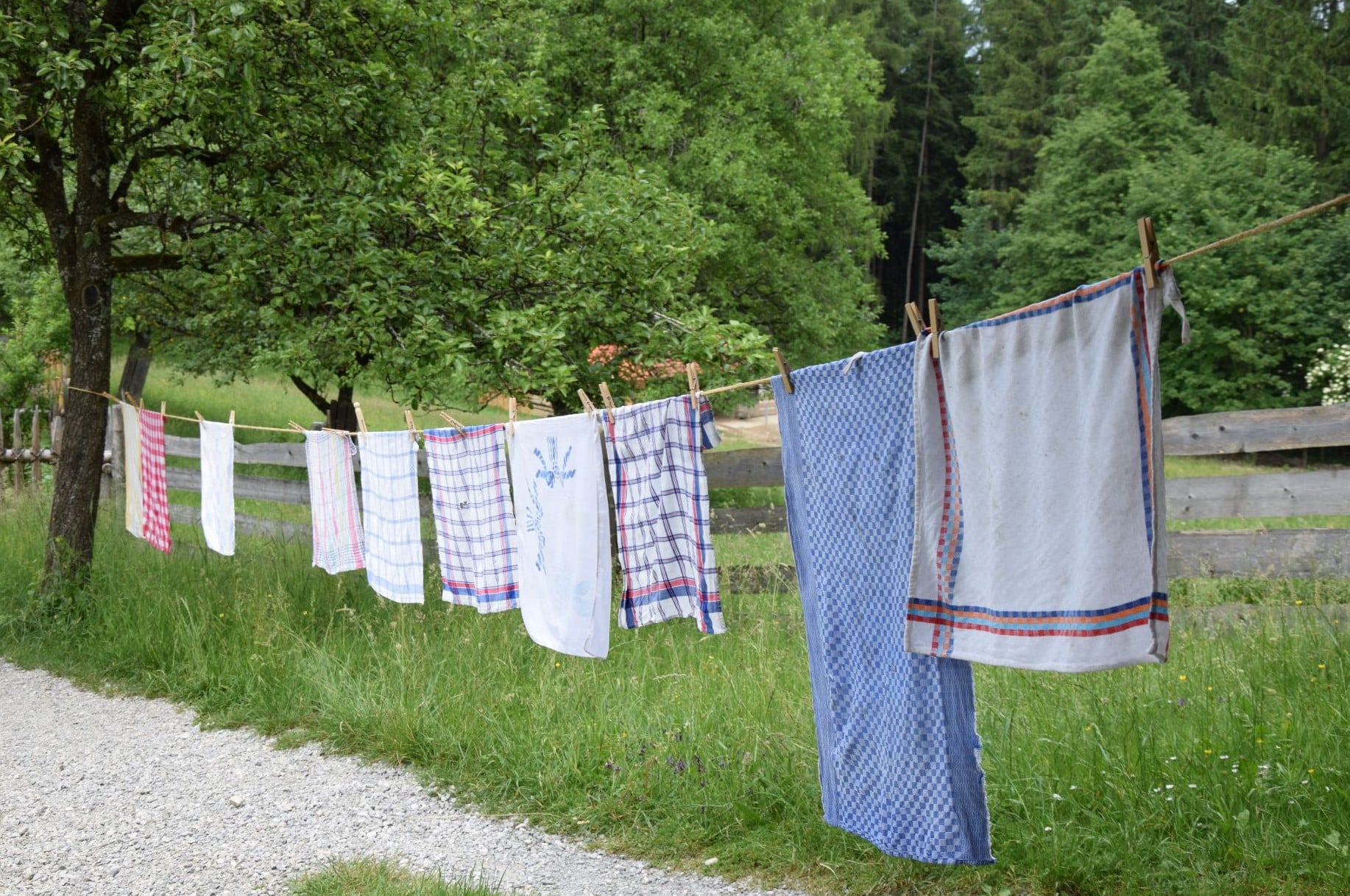 Auf einer Wäscheleine im Freien sind mehrere Tücher in verschiedenen Farben aufgehängt.