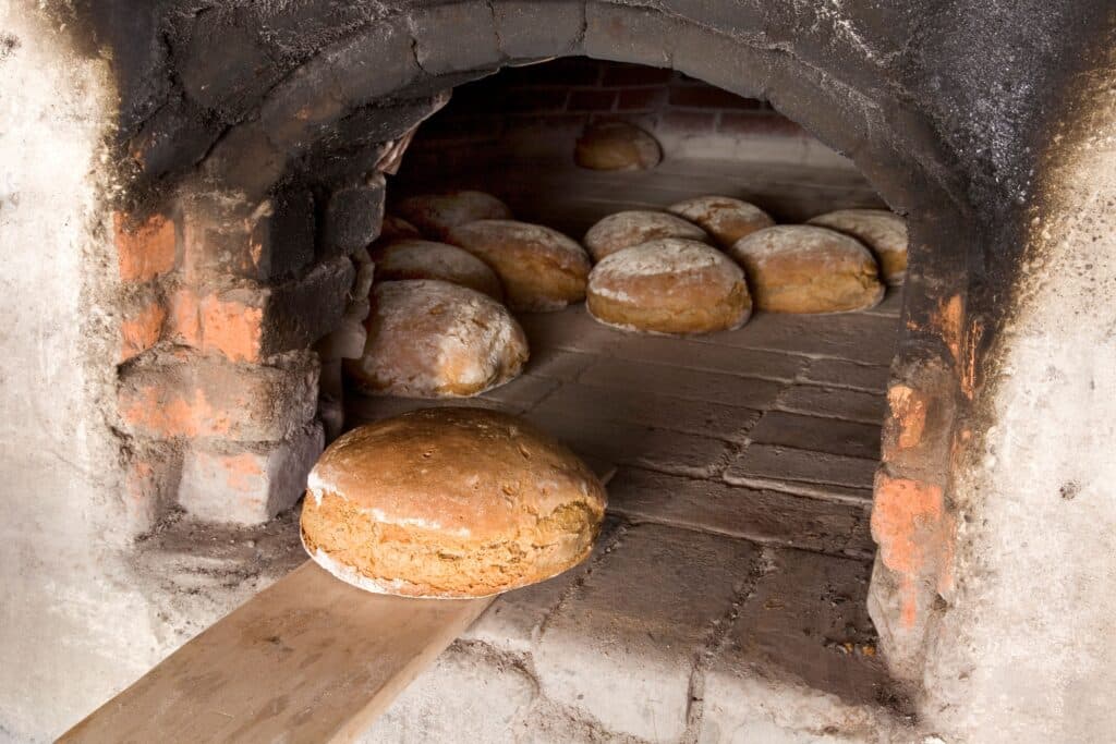 Fertig gebackenes Brot liegt in einem alten Backofen.